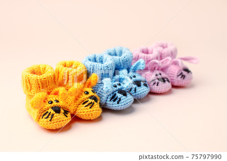 Baby shower, gender party. Boy, girl, queer, neatral. Three pairs of baby socks, booties with funny bunny decor, celebration concept when the gender of the child becomes known Baby shower, gender party. Boy, girl, queer, neatral. Three pairs of baby socks, booties with funny bunny decor, celebration concept when the gender of the child becomes known 75797990