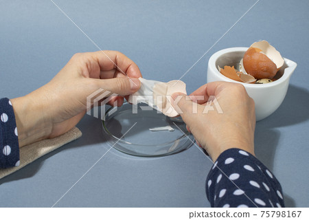 Women hands remowing eggshell membrane. Zero waste cosmetics. Women hands remowing eggshell membrane. Zero waste cosmetics. 75798167