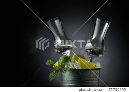 Strong alcoholic drink with lime and mint in a metal bucket with ice. Strong alcoholic drink with lime and mint in a metal bucket with ice. 75799395