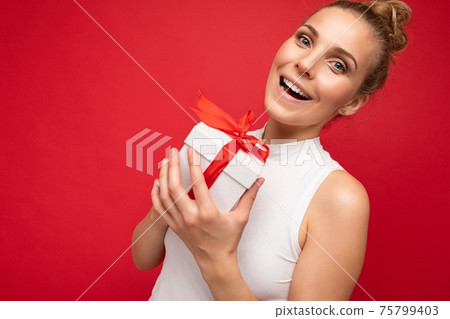 Delightful beautiful positive smiling amazed young blonde female person isolated over red background Delightful beautiful positive smiling amazed young blonde female person isolated over red background 75799403