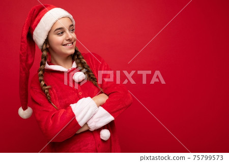 Photo shot of beautiful happy positive smiling brunette girl with pigtails wearing santa clause Photo shot of beautiful happy positive smiling brunette girl with pigtails wearing santa clause 75799573