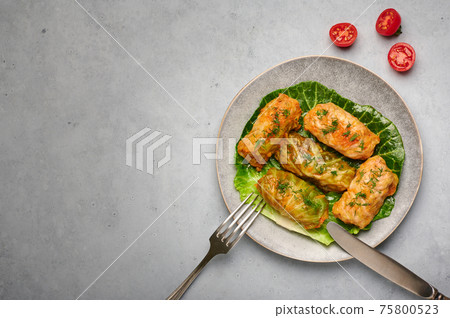 Golubtsi or golabki on plate on concrete table top. Stuffed cabbage rolls of russian, polish cuisine Golubtsi or golabki on plate on concrete table top. Stuffed cabbage rolls of russian, polish cuisine 75800523