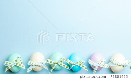 Easter flat. Colorful egg with tape ribbon on pastel blue background in Happy Easter decoration. Spring holiday top view concept. Easter flat. Colorful egg with tape ribbon on pastel blue background in Happy Easter decoration. Spring holiday top view concept. 75801433