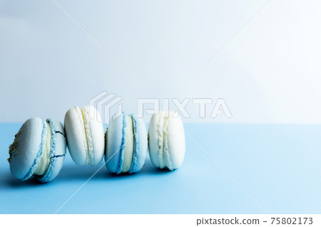 White and blue macaroons on the table, macaroons on white blue background 75802173