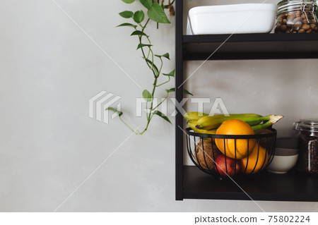 Black metal shelves in kitchen, gray concrete wall, loft style. Green flowerpots Black metal shelves in kitchen, gray concrete wall, loft style. Green flowerpots 75802224