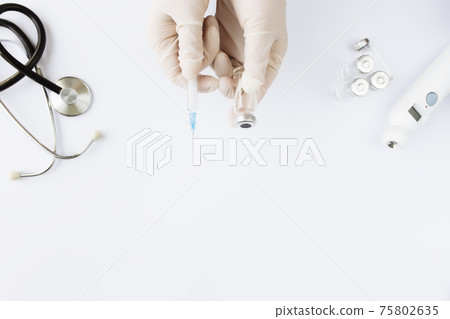 Doctor hands holding bottle with vaccine and syringe, thermometer, stethoscope Doctor hands holding bottle with vaccine and syringe, thermometer, stethoscope 75802635