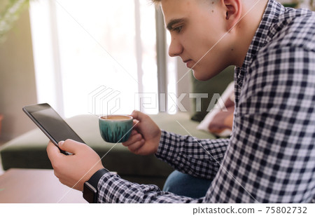 Man reading smartphone with black screen and coffee cup. Blurred background Man reading smartphone with black screen and coffee cup. Blurred background 75802732