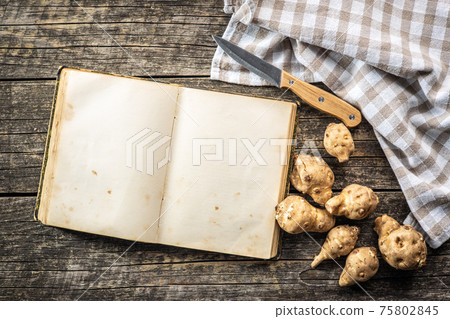 Blank cookbook and raw jerusalem artichoke. Topinambur vegetable root. Blank cookbook and raw jerusalem artichoke. Topinambur vegetable root. 75802845