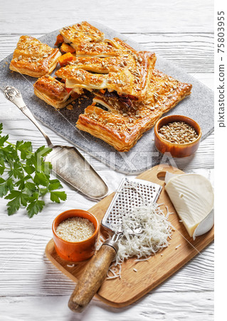Vegetable puff pastry pie on a white wooden table 75803955