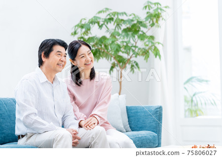 A middle-aged couple relaxing in the living room 75806027
