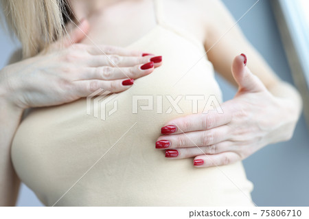 Woman palpating her breasts with hands closeup Woman palpating her breasts with hands closeup 75806710