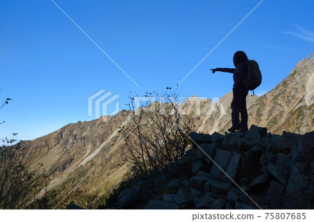 Antelope position. (Northern Alps, between Takezawa-Kimikodaira-Maehotakadake.) A climber pointing to Kamikochi. Hanging ridge in the background. Antelope position. (Northern Alps, between Takezawa-Kimikodaira-Maehotakadake.) A climber pointing to Kamikochi. Hanging ridge in the background. 75807685