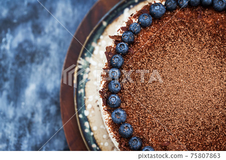 Delicious homemade sour cream vanilla cake decorated with chocolate and fresh blueberry 75807863
