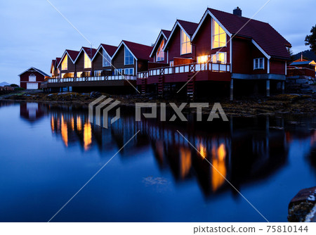 Camping cabins on a fjord at night 75810144