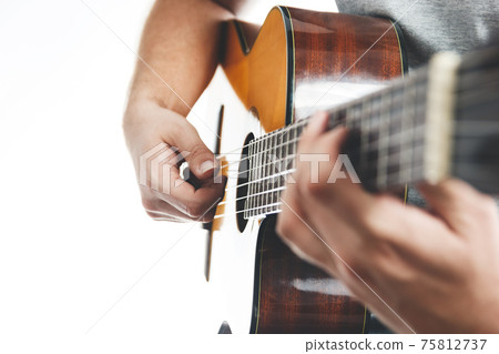 Close up of human's hands playing flamenco guitar. Musical instrument for recreation or hobby passion concept. 75812737