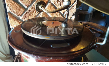 Gramophone with plate or vinyl disk. Antique brass record player. Gramophone with horn speaker. 75812917