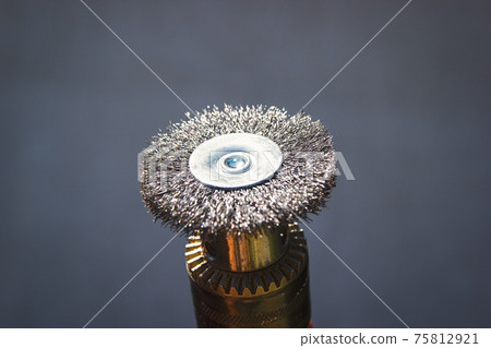 Steel attachment brush for an electric drill on a gray background for wood processing of metal cleaning 75812921