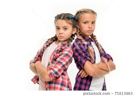 Girls sisters stand back to back confidently. Friendship 75813863