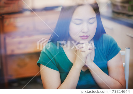 woman praying and worship to GOD Using hands to pray in religious beliefs and worship christian in the church or in general locations in vintage color tone or copy space. woman praying and worship to GOD Using hands to pray in religious beliefs and worship christian in the church or in general locations in vintage color tone or copy space. 75814644