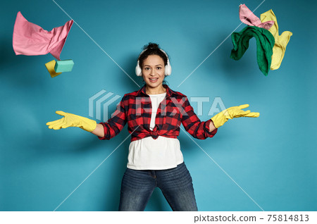 Young woman throws cleaning supplies and smiles to the camera. Housework and cleaning concept. Young woman throws cleaning supplies and smiles to the camera. Housework and cleaning concept. 75814813