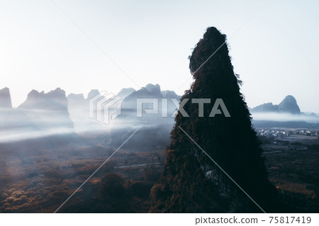 Aerial footage of beautiful sunrise over foggy karst mountain peak landscape Aerial footage of beautiful sunrise over foggy karst mountain peak landscape 75817419