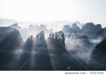 Aerial footage of beautiful sunrise over foggy karst mountain peak landscape Aerial footage of beautiful sunrise over foggy karst mountain peak landscape 75817420