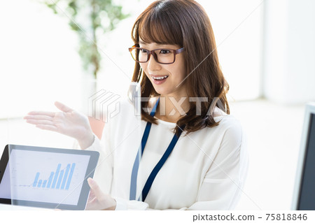 A woman talking over an acrylic partition while showing materials on a tablet PC A woman talking over an acrylic partition while showing materials on a tablet PC 75818846
