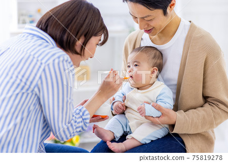 Baby trying to eat baby food Baby trying to eat baby food 75819278