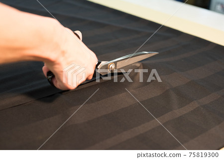 一位在服裝廠剪布料的工匠 75819300