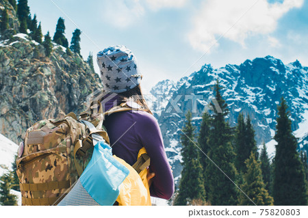 Traveling girl with backpack hiking in the mountains, freedom concept. Hiking people on Asia. Beautiful young woman traveler with a backpack looks at the mountain top before climbing Traveling girl with backpack hiking in the mountains, freedom concept. Hiking people on Asia. Beautiful young woman traveler with a backpack looks at the mountain top before climbing 75820803