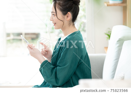 Young woman looking at a smartphone Young woman looking at a smartphone 75823566