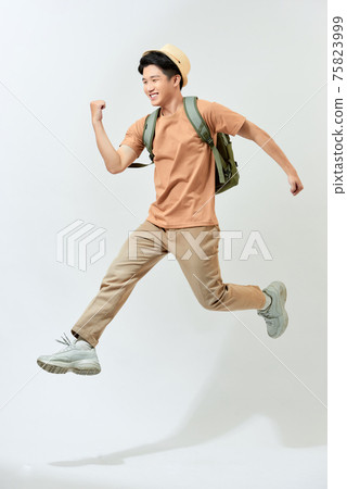 young man with backpack celebrating in mid air, movement jumping isolated in studio young man with backpack celebrating in mid air, movement jumping isolated in studio 75823999