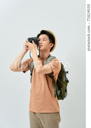 Young cheerful man photographer takes images with digital camera 75824030