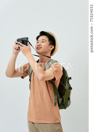 A man with a passport and plane tickets goes on a trip and a professional camera on his neck 75824032