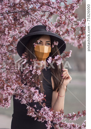 Portrait of a young woman in the spring flowers of a tree. Portrait of a young woman in the spring flowers of a tree. 75826000