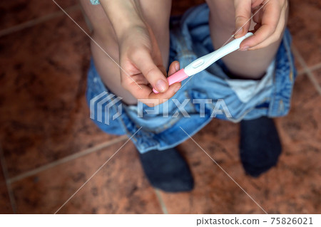 Young woman checking results of a pregnancy test in bathroom close-up, new life,family,mother,baby concept Young woman checking results of a pregnancy test in bathroom close-up, new life,family,mother,baby concept 75826021