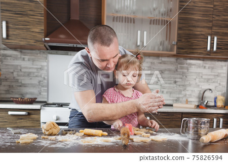 happy dad makes cookies with his little daughter sifts flour through his hands happy dad makes cookies with his little daughter sifts flour through his hands 75826594
