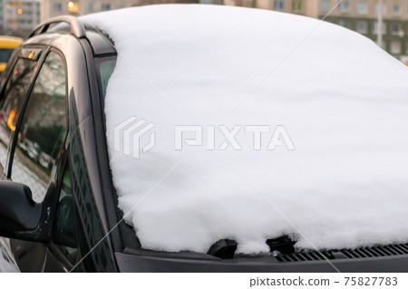 Windshield covered with snow of a parked car. Windshield covered with snow of a parked car. 75827783