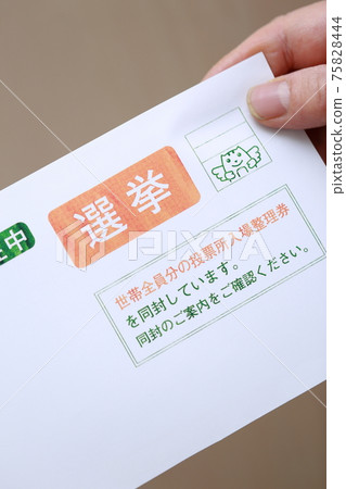 Senior hand holding an election envelope Senior hand holding an election envelope 75828444