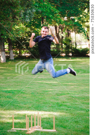 Boy playing a game throwing rings outdoors in summer park. Boy playing a game throwing rings outdoors in summer park. 75830630