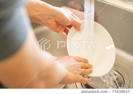 Hands of a man washing dishes Hands of a man washing dishes 75830637