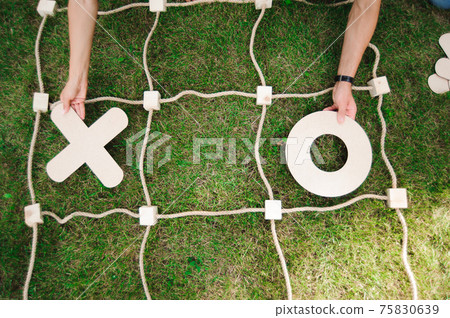 Tic tac toe game on the green grass. Tic tac toe game on the green grass. 75830639