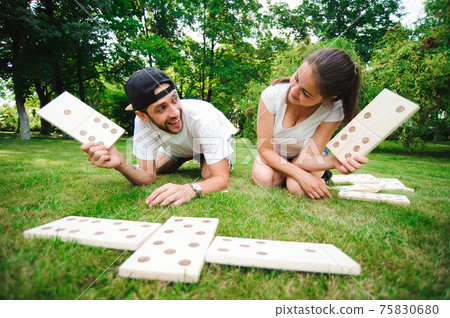 Friends domino players on the green grass. Friends domino players on the green grass. 75830680