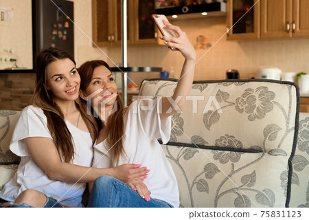 Close up portrait of two excited girlfriends with mobile phones, laughing. Happy joyful female Close up portrait of two excited girlfriends with mobile phones, laughing. Happy joyful female 75831123