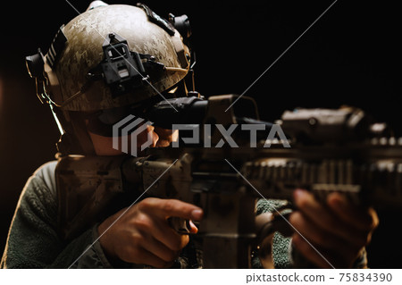 US special forces soldier looking at the aim ready to shoot against black dark background US special forces soldier looking at the aim ready to shoot against black dark background 75834390