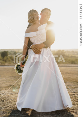 Portrait of a bride and groom in a sunset light Portrait of a bride and groom in a sunset light 75834391