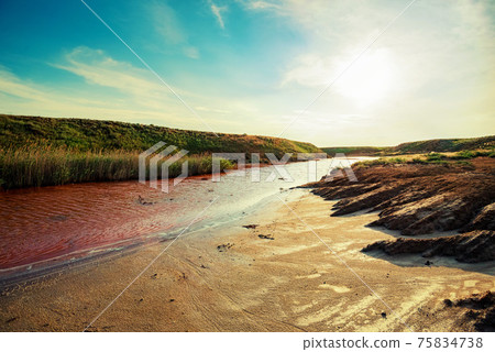 View of small red water river full of iron in beautiful steppe 75834738