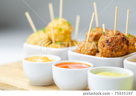 Various mini chicken kievs and sweet potato falafels served with sauces Various mini chicken kievs and sweet potato falafels served with sauces 75835197