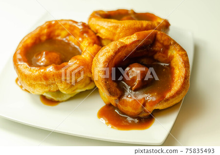 Traditional English Yorkshire pudding with meatballs and thick gravy sauce Traditional English Yorkshire pudding with meatballs and thick gravy sauce 75835493