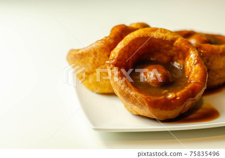 Traditional English Yorkshire pudding with meatballs and thick gravy sauce Traditional English Yorkshire pudding with meatballs and thick gravy sauce 75835496